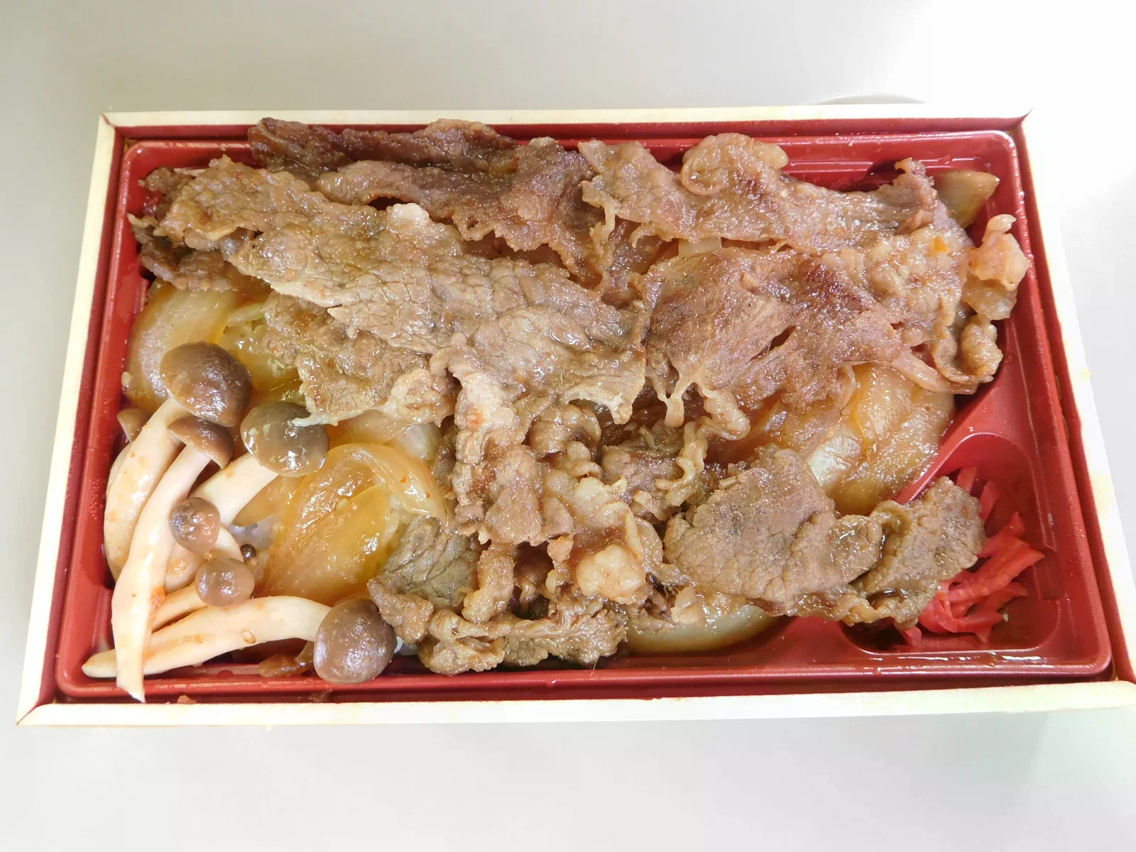 便當盒裡鋪著飛驒牛肉片、洋蔥與菇類