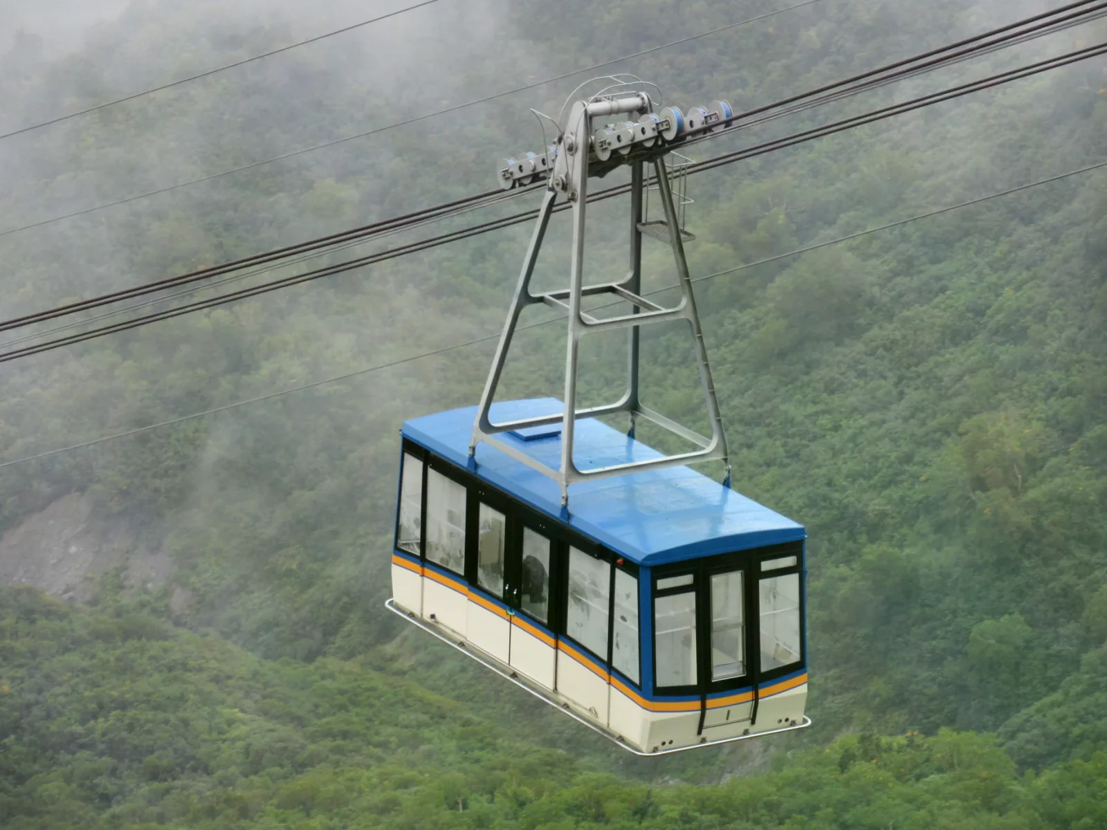 立山空中纜車藍白車廂行經山谷