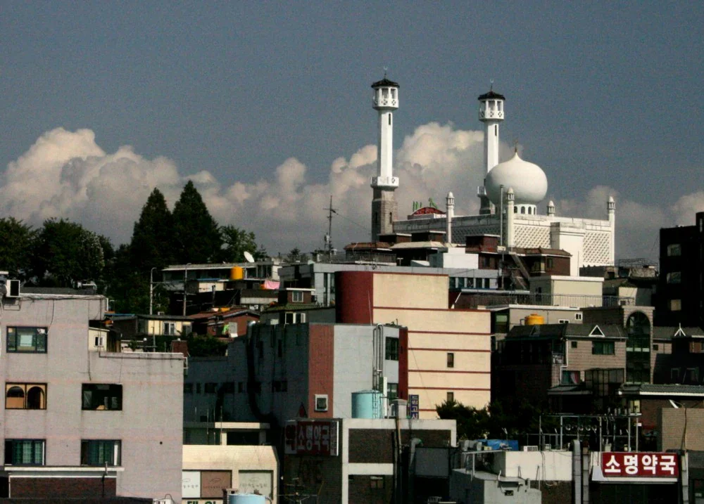 梨泰院街區遠望首爾中央清真寺的圓頂與宣禮塔，前景是社區住宅