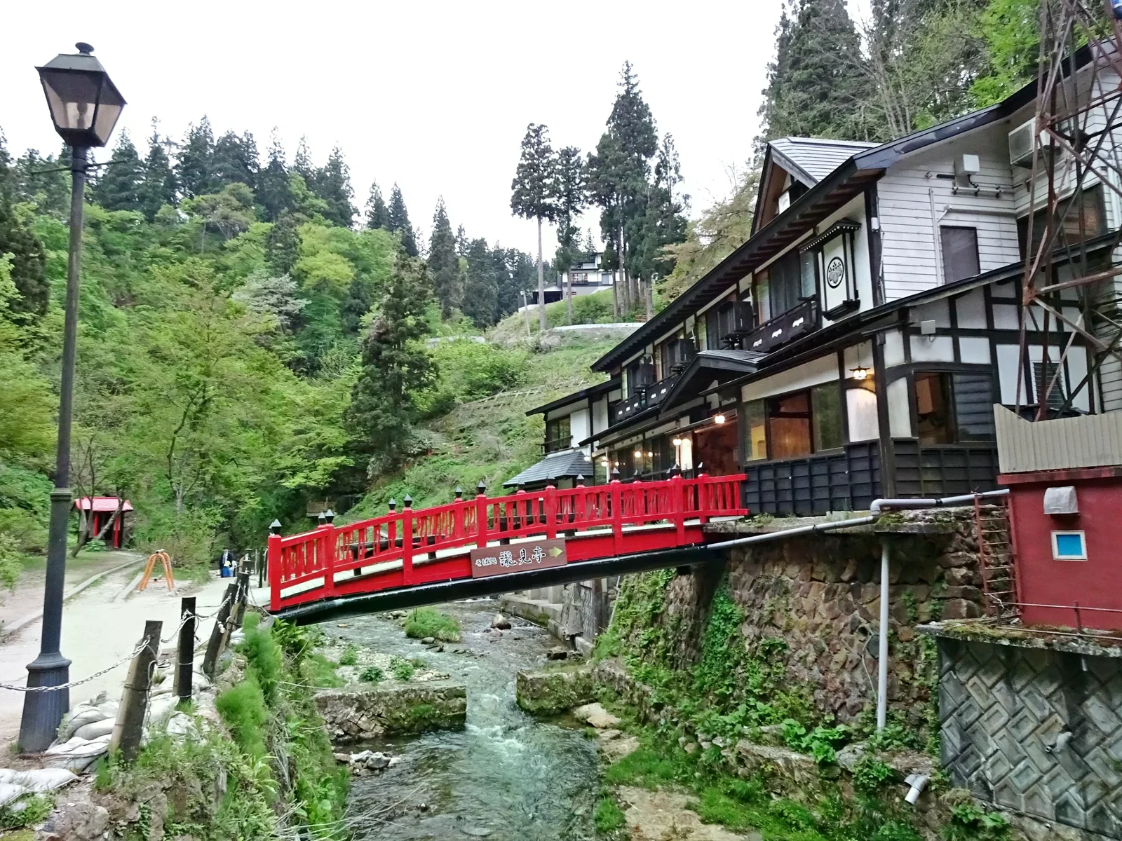 銀山溫泉紅色瀧見橋跨過溪流，旁邊是旅館