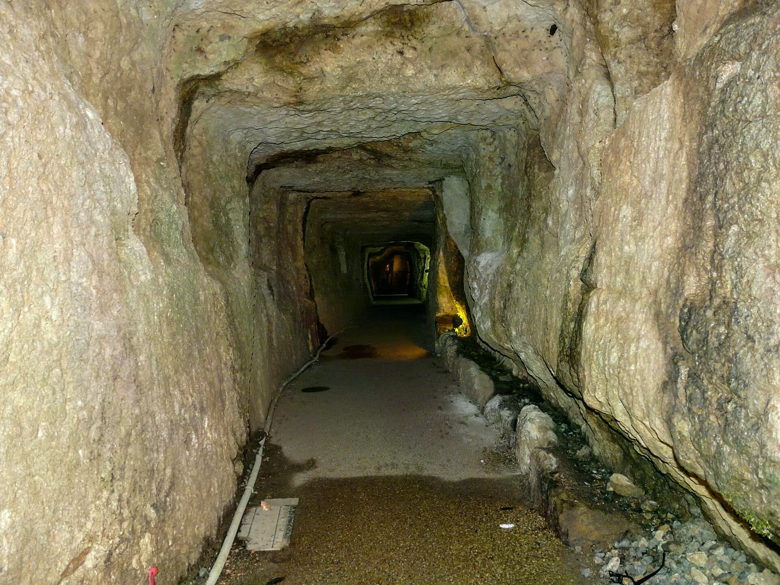 龍源寺間步坑道內部的粗糙岩壁與向前延伸的窄道