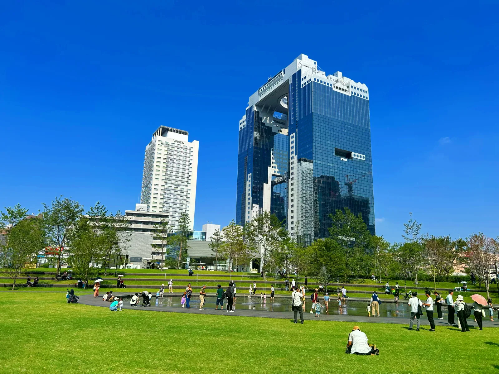 梅田藍天大廈從前方草坪廣場望去，雙塔以頂端空中庭園相連。