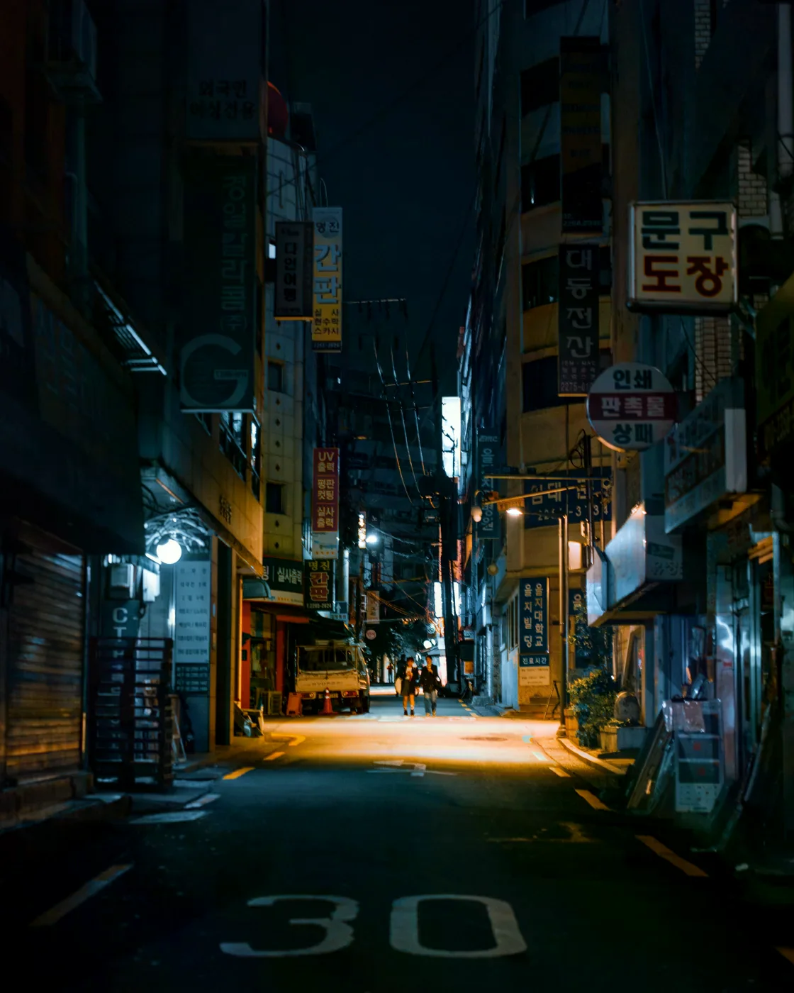 首爾夜間街道，路旁有韓文招牌與路燈