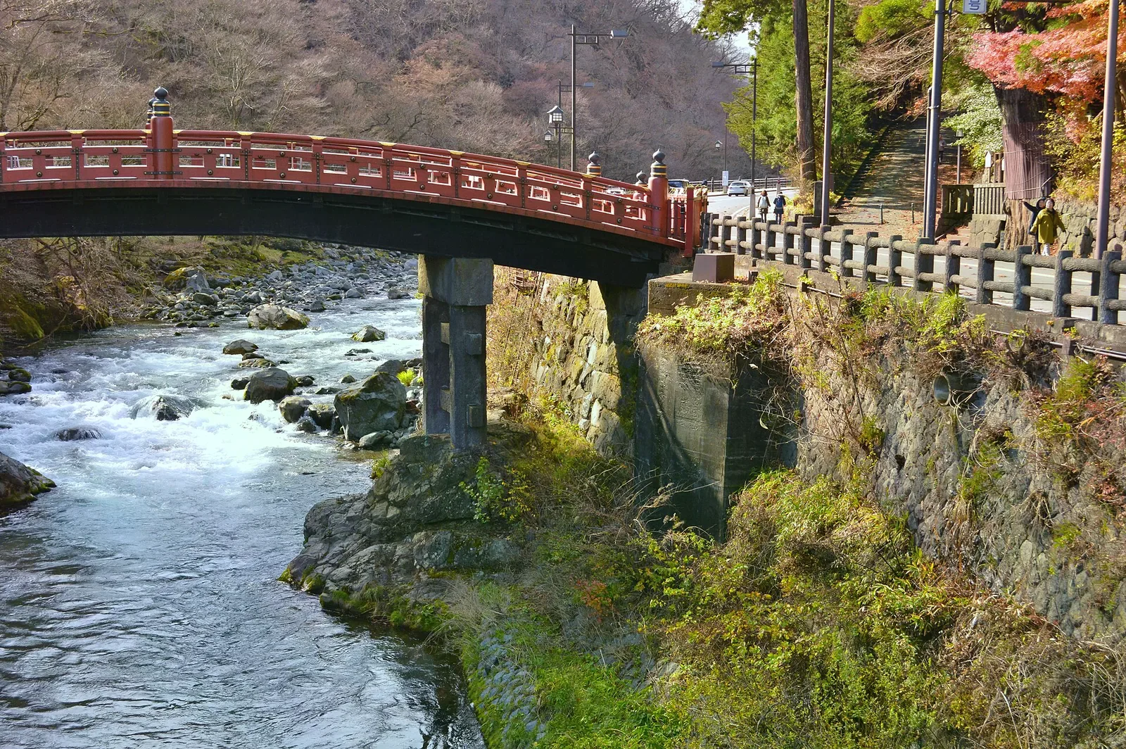 紅漆神橋橫跨大谷川，橋下溪水奔騰，兩旁是晚秋枯木