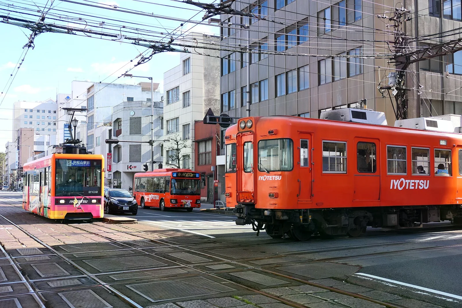 松山市大手町的伊予鐵道路面電車、郊外線列車與巴士同框，2020 年照片