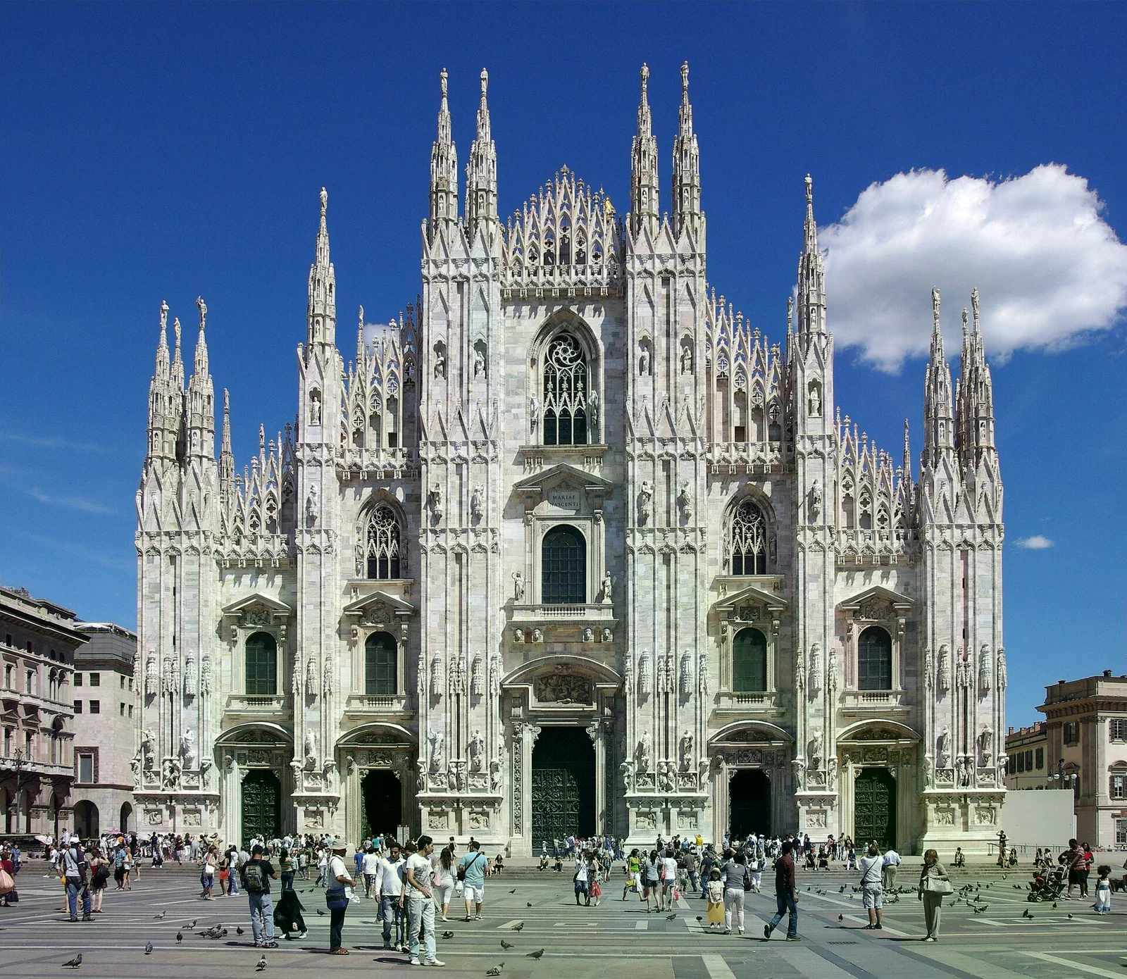 米蘭大教堂（Duomo di Milano）白色大理石哥德式立面與尖塔，廣場上有遊客。