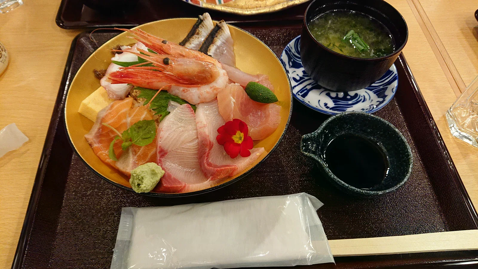 海鮮丼上的蝦與魚片，旁有味噌湯