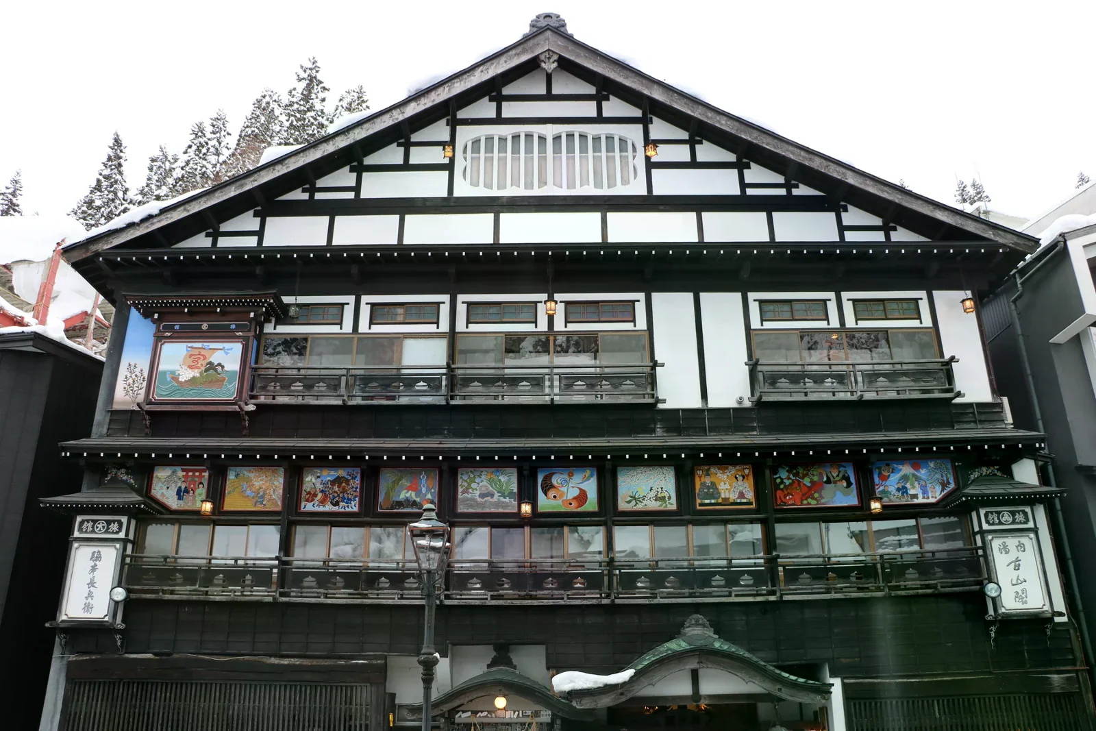 古山閣木造旅館正面，屋簷與樹木覆著積雪