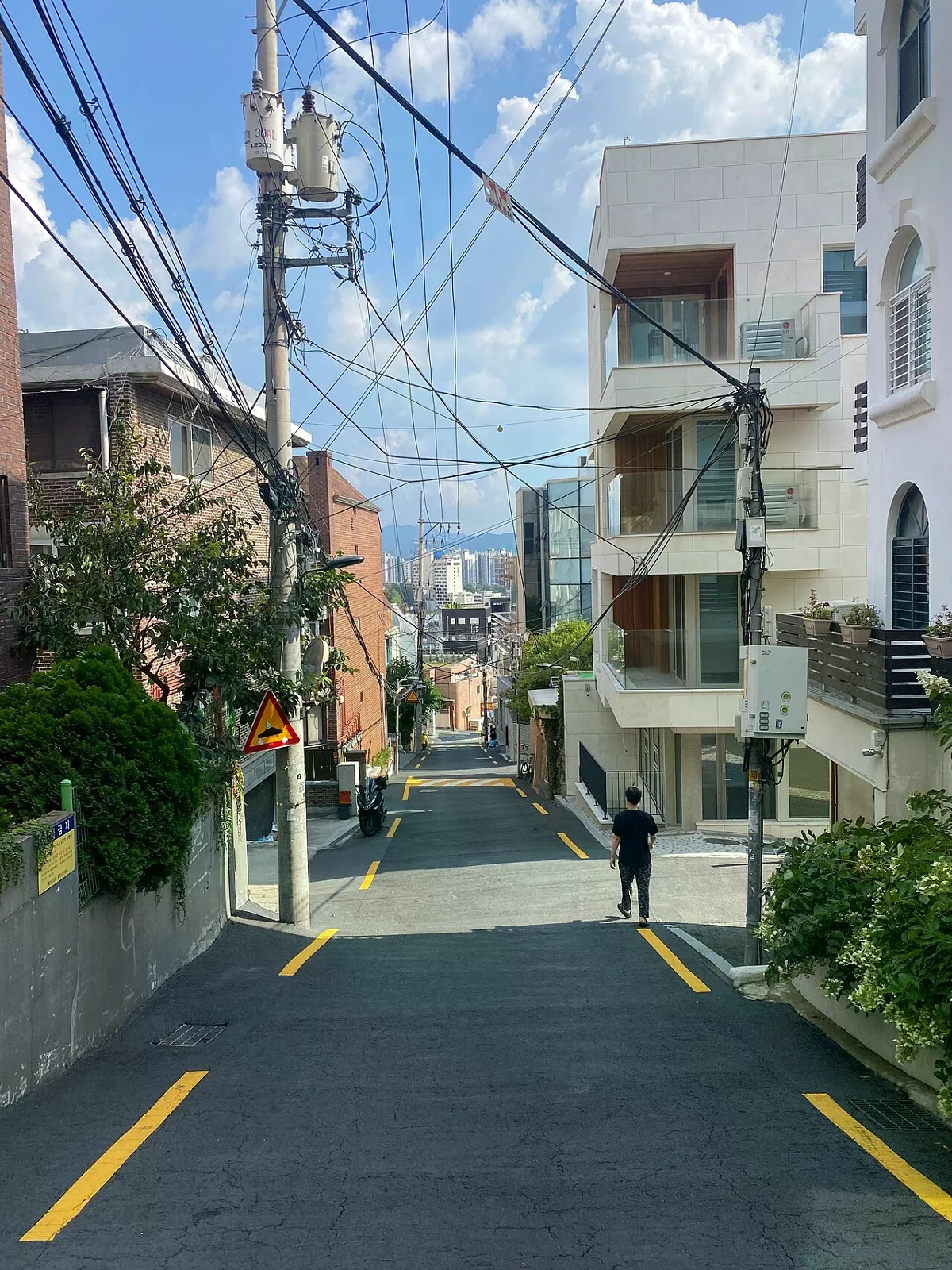 解放村住宅區的陡坡道路向下延伸，兩側可見建築