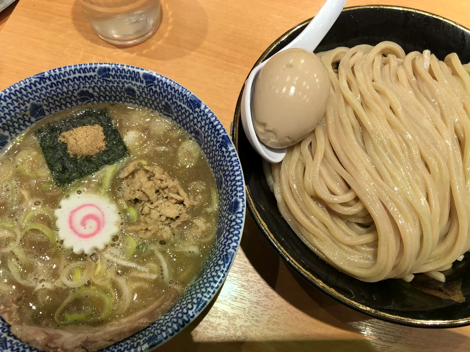粗麵與蛋放在黑碗，另一碗盛沾汁
