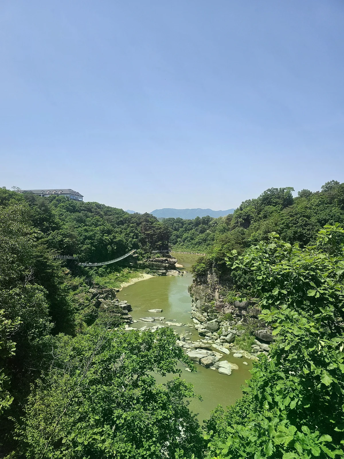 從高處俯瞰漢灘江河谷，棧道沿左側岩壁延伸，兩岸可見樹林與岩層