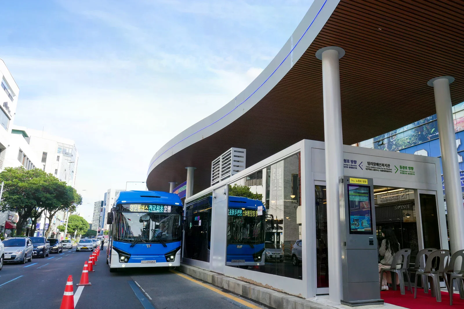 濟州市島式公車站的藍色公車與候車區。