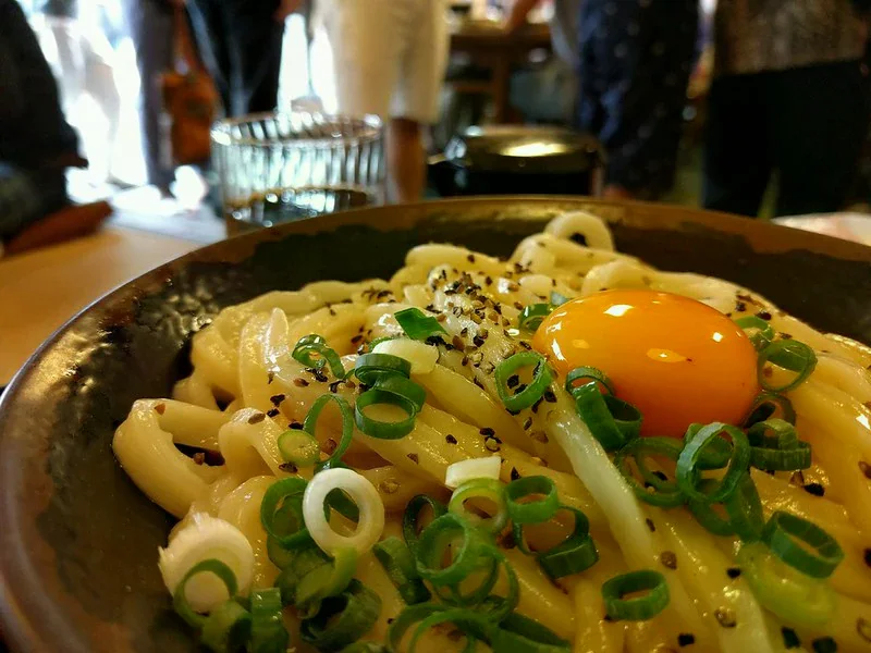 烏龍麵上有蛋黃、奶油、蔥與胡椒
