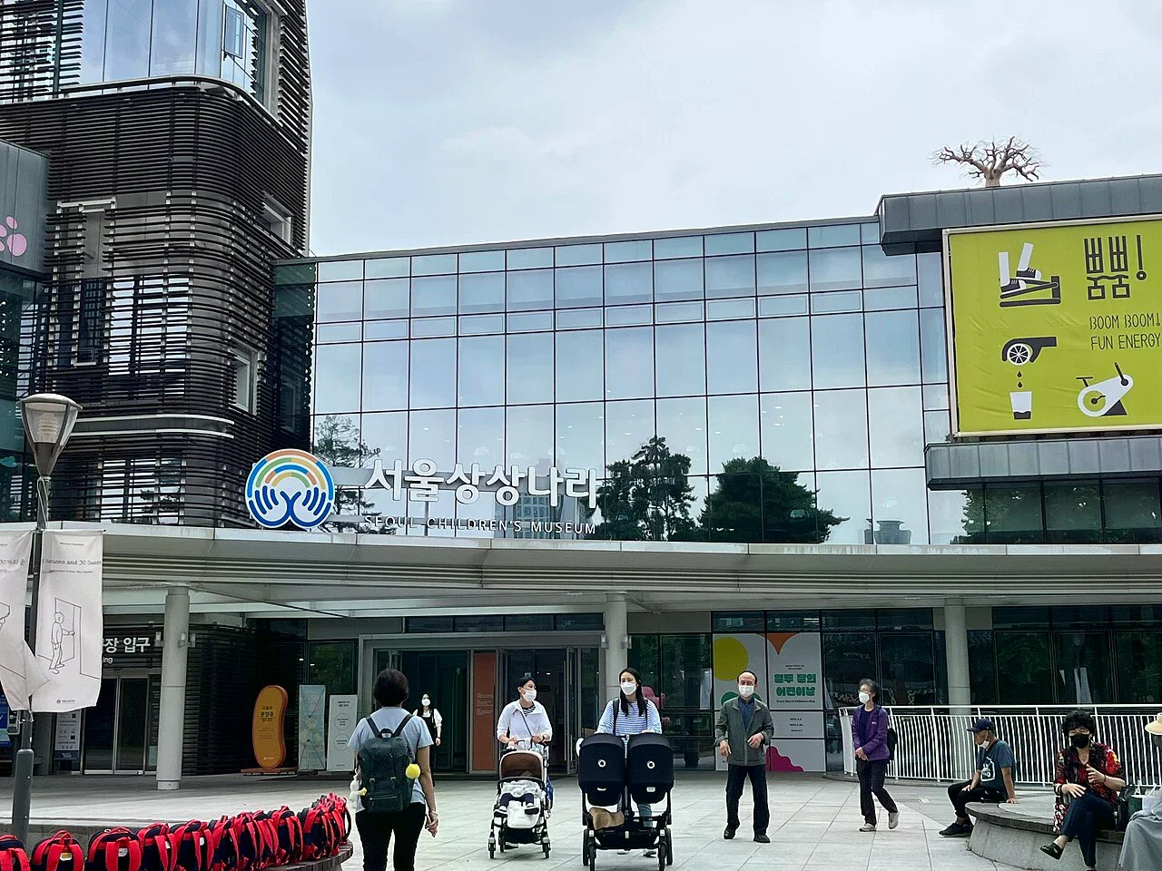 首爾兒童博物館玻璃外牆與韓文館名，入口前可見推車和等候者
