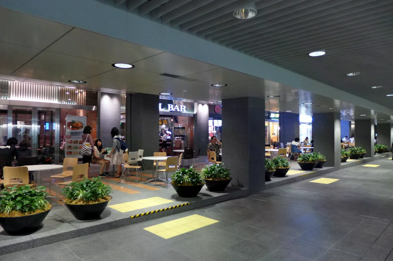 札幌地下步行空間旁可見餐飲店面、桌椅與植栽