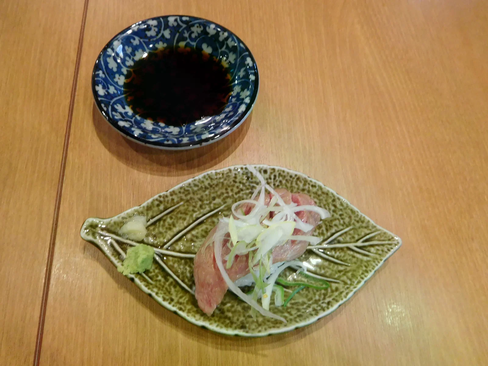 盤中擺著飛驒牛握壽司與一碟醬油