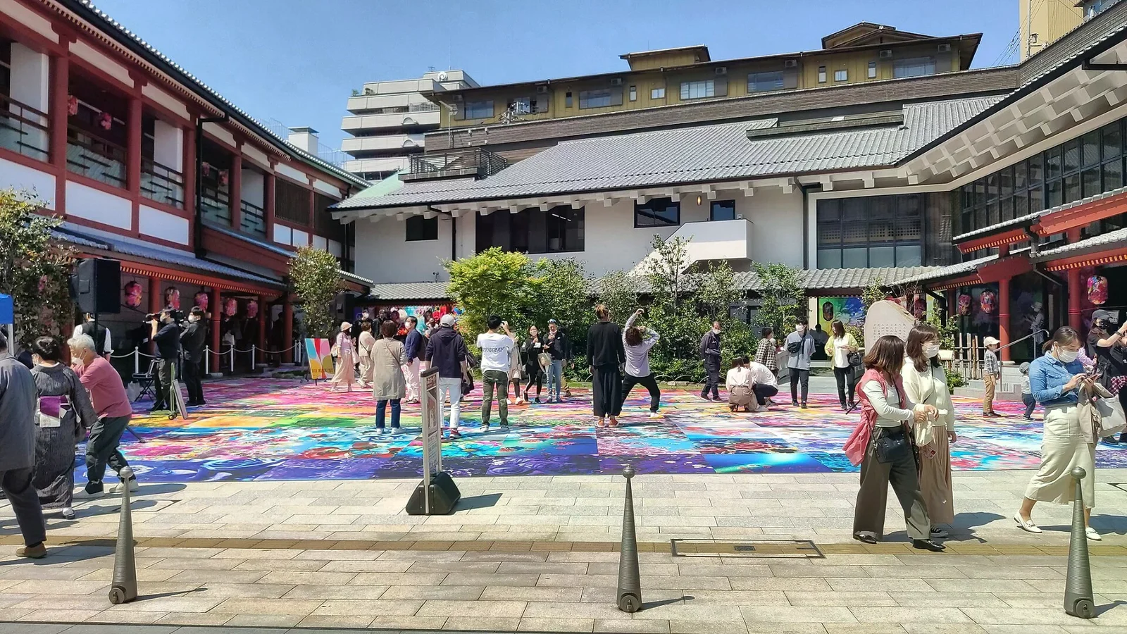 椿之湯前方廣場的彩色地面與散步人群，2022 年照片