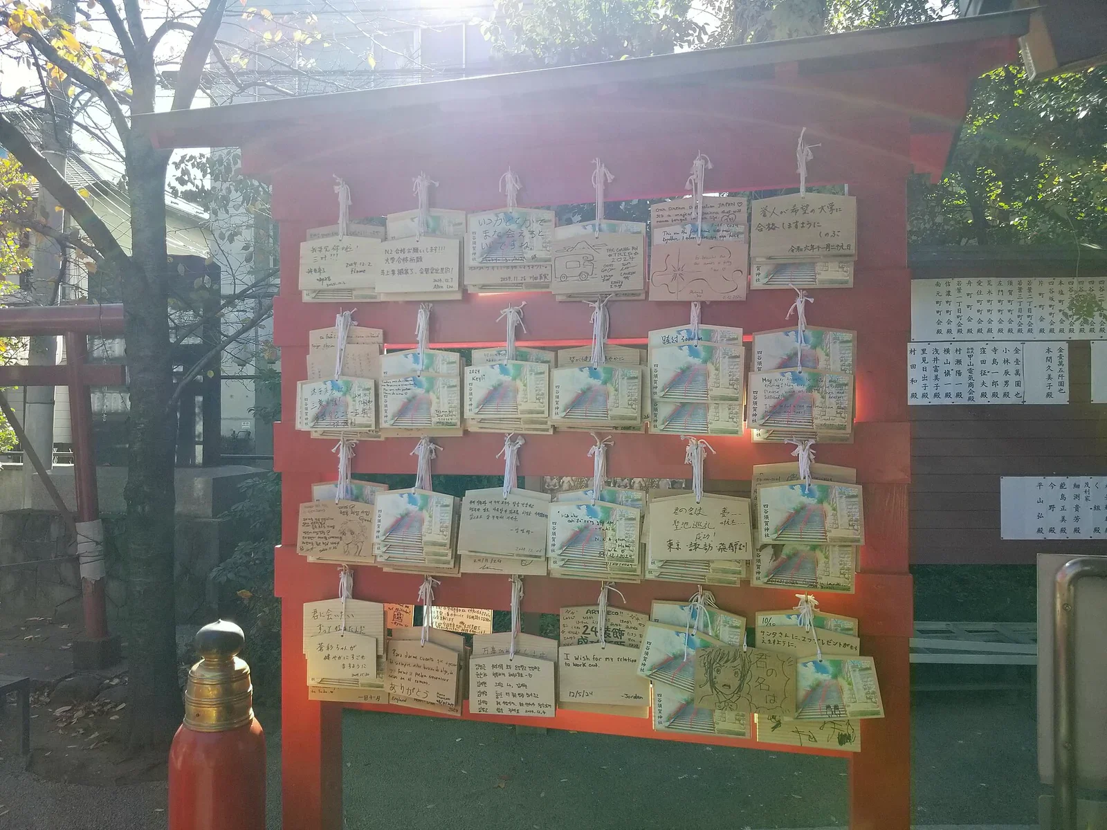 神社紅色木架上掛滿寫滿願望的木製繪馬