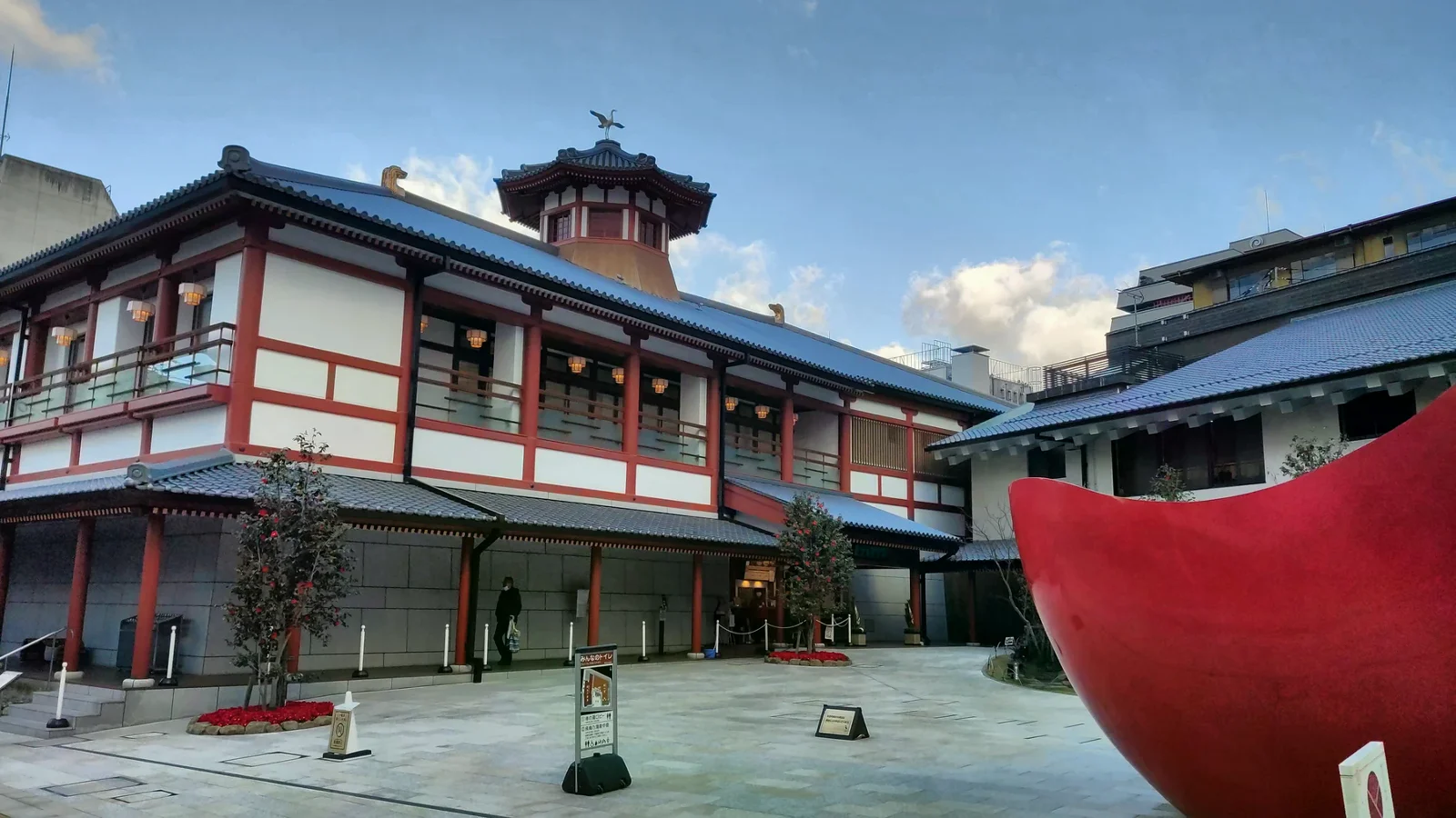 飛鳥乃湯泉的紅白建築、入口前廣場與屋頂上的白鷺裝飾