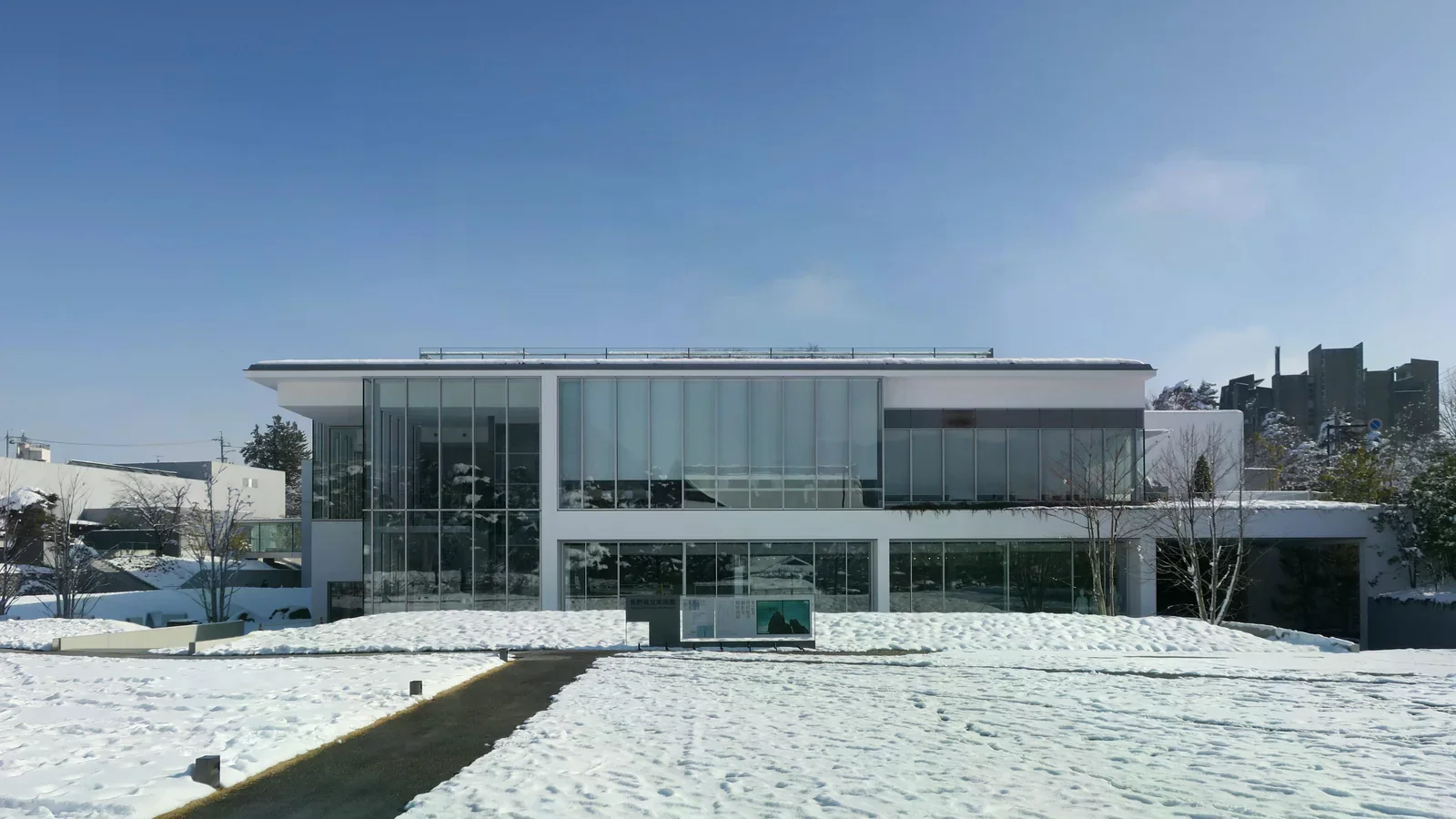 雪地前方的長野縣立美術館低矮玻璃外觀