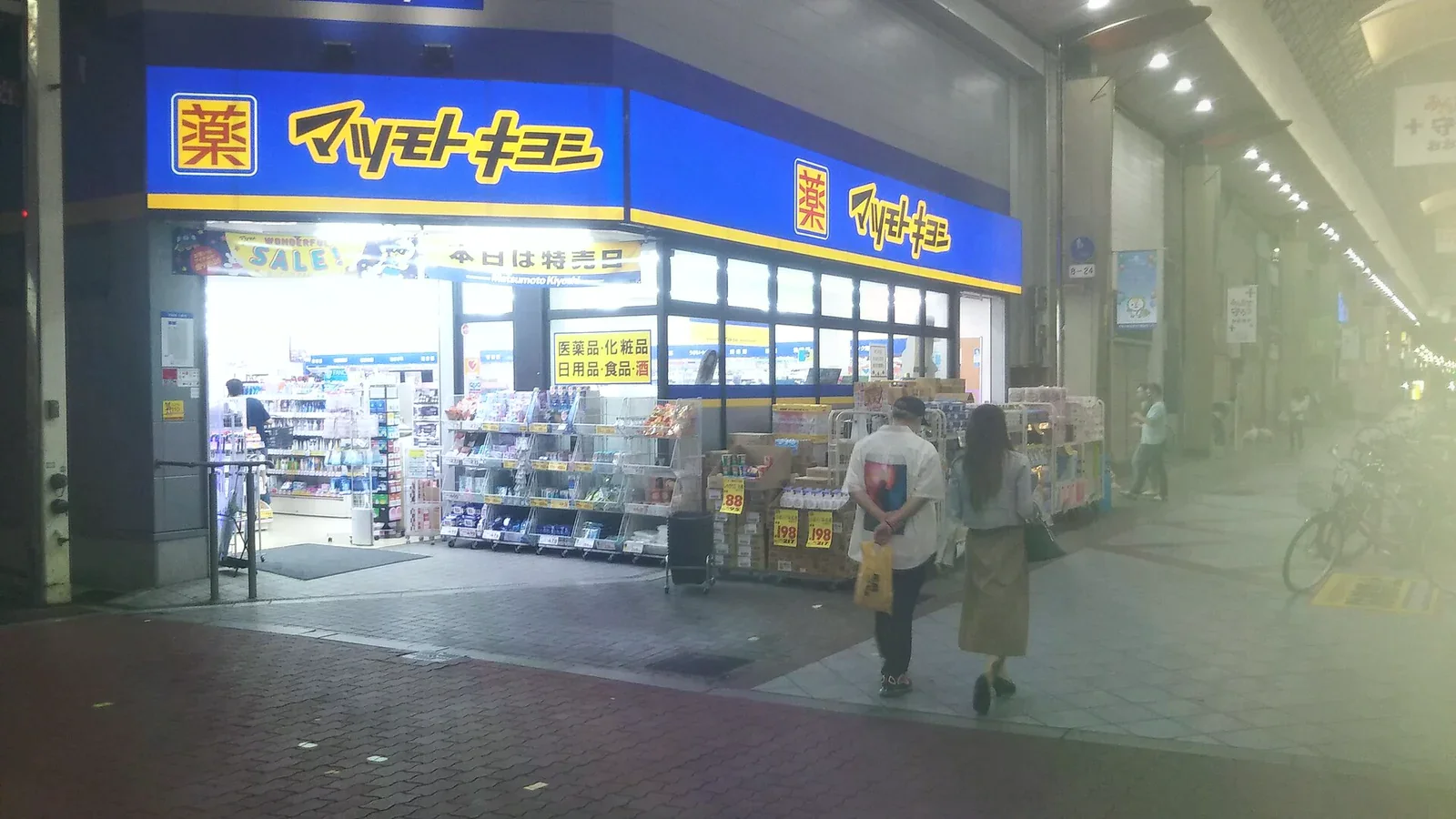 黃昏時分的松本清門市，藍色藥店招牌與店外陳列架清晰可見