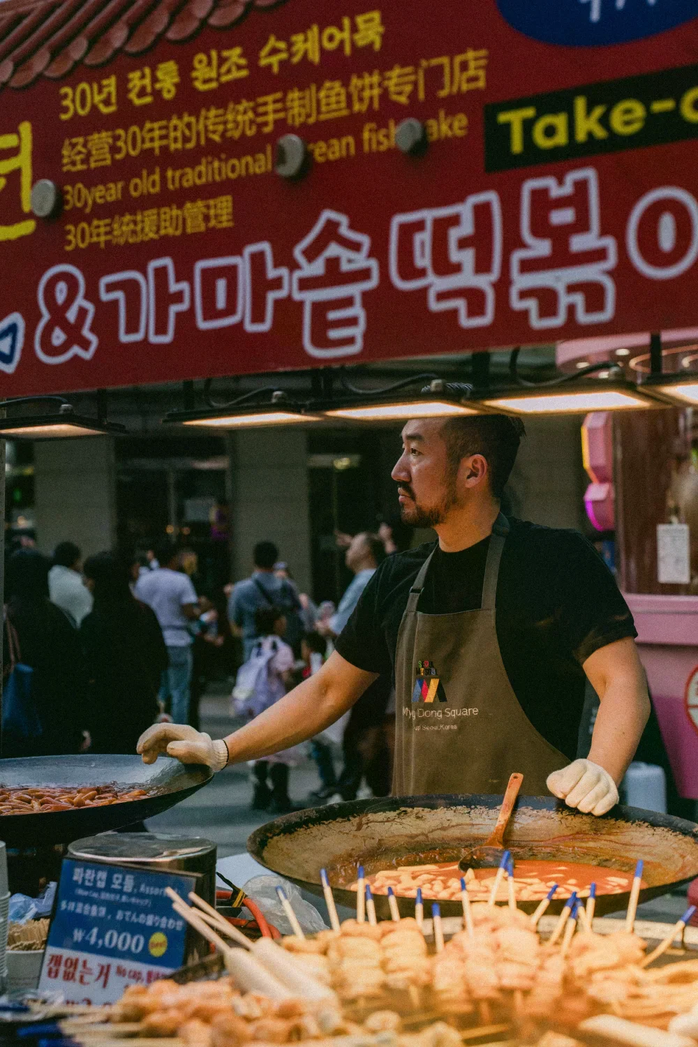 夜間市場攤販在料理食物，攤位前有顧客