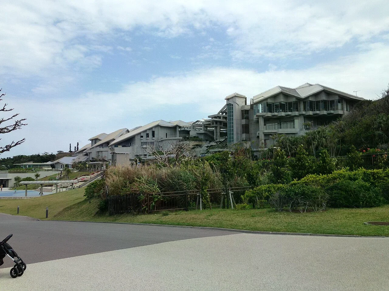 沖繩美麗海水族館建築外觀，入口周邊可見園區步道與植栽