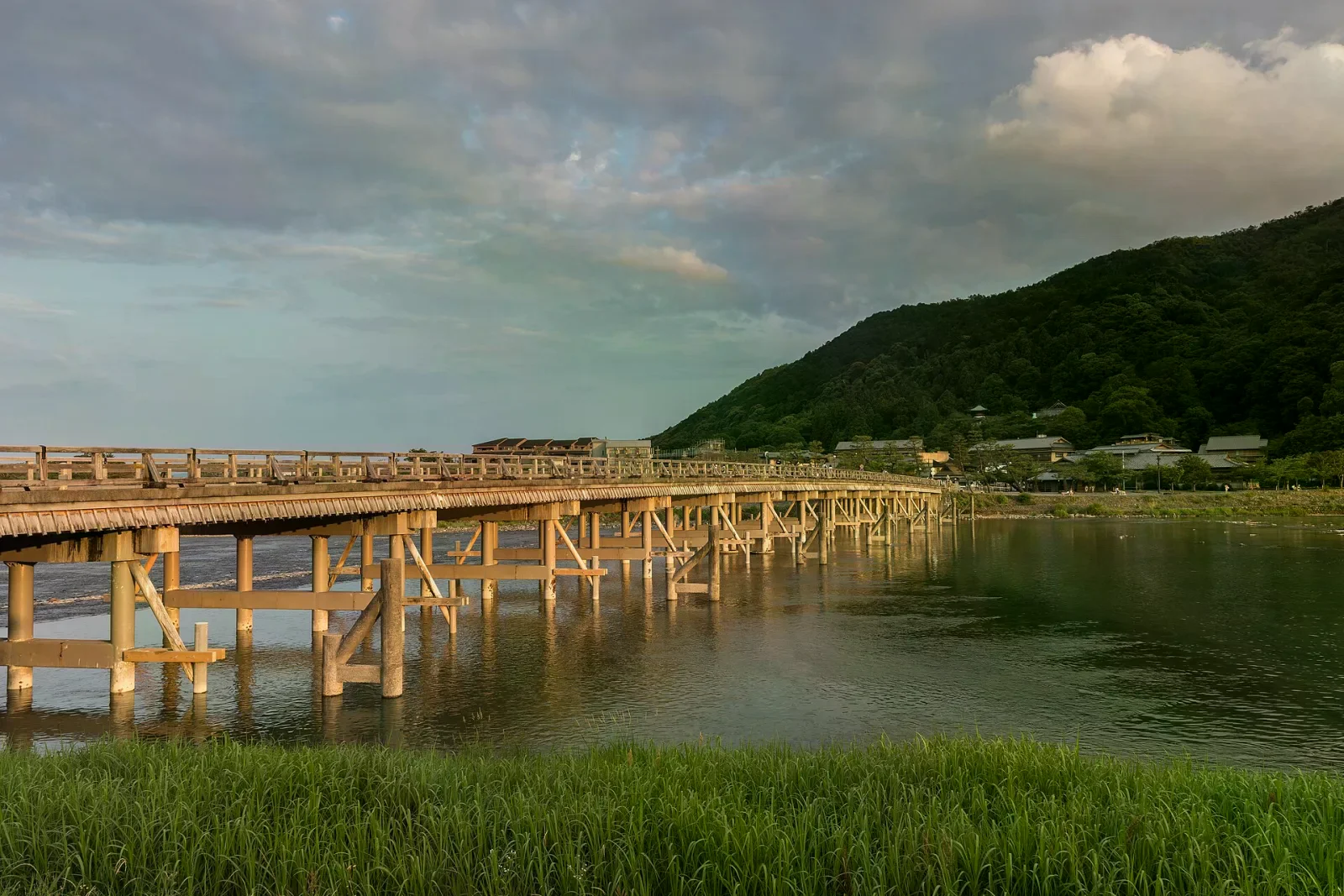 渡月橋木構橋跨越桂川，背景是山巒