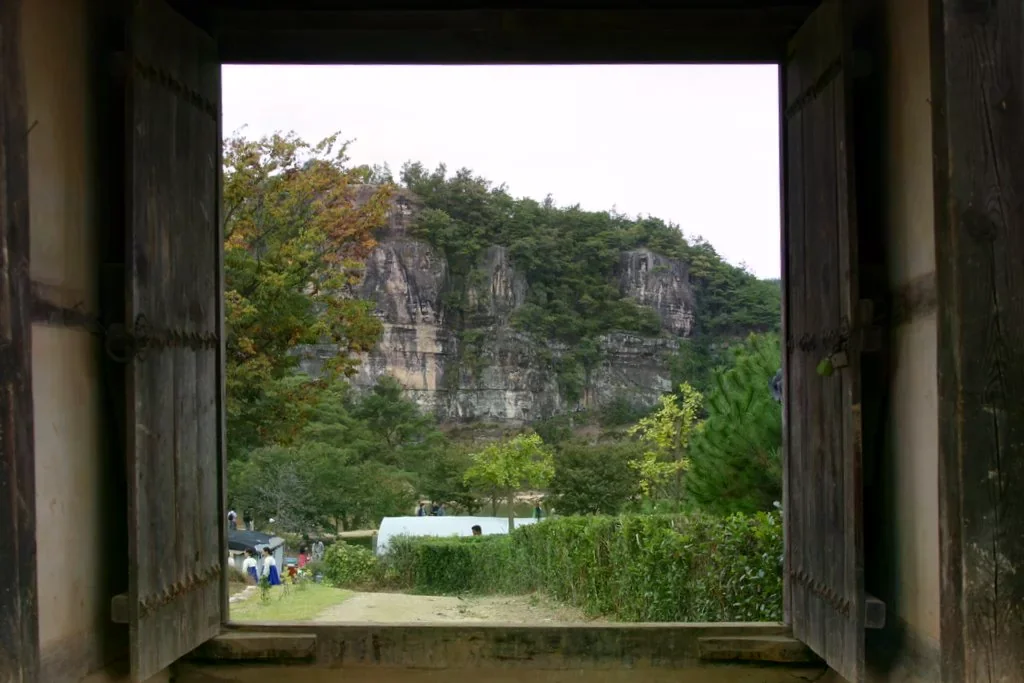 透過河回村的傳統門框望向芙蓉臺山壁