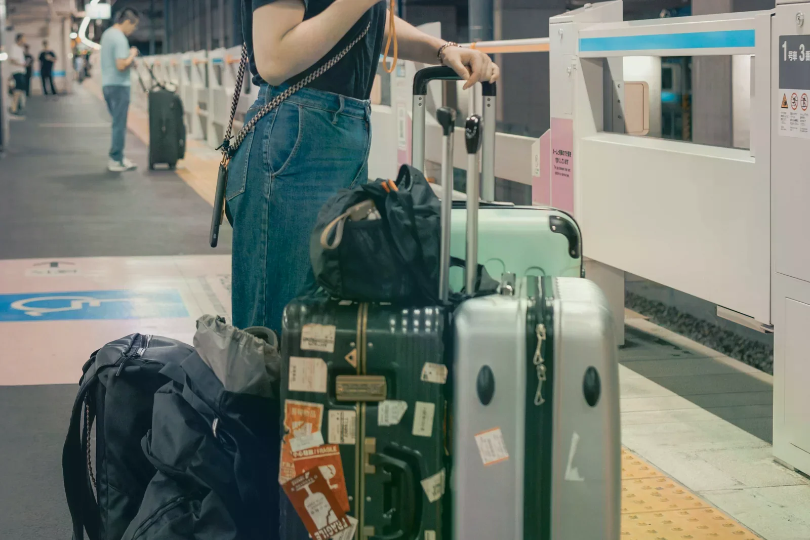 東京市內車站旅客帶著行李候車的交通情境照，非機場實景