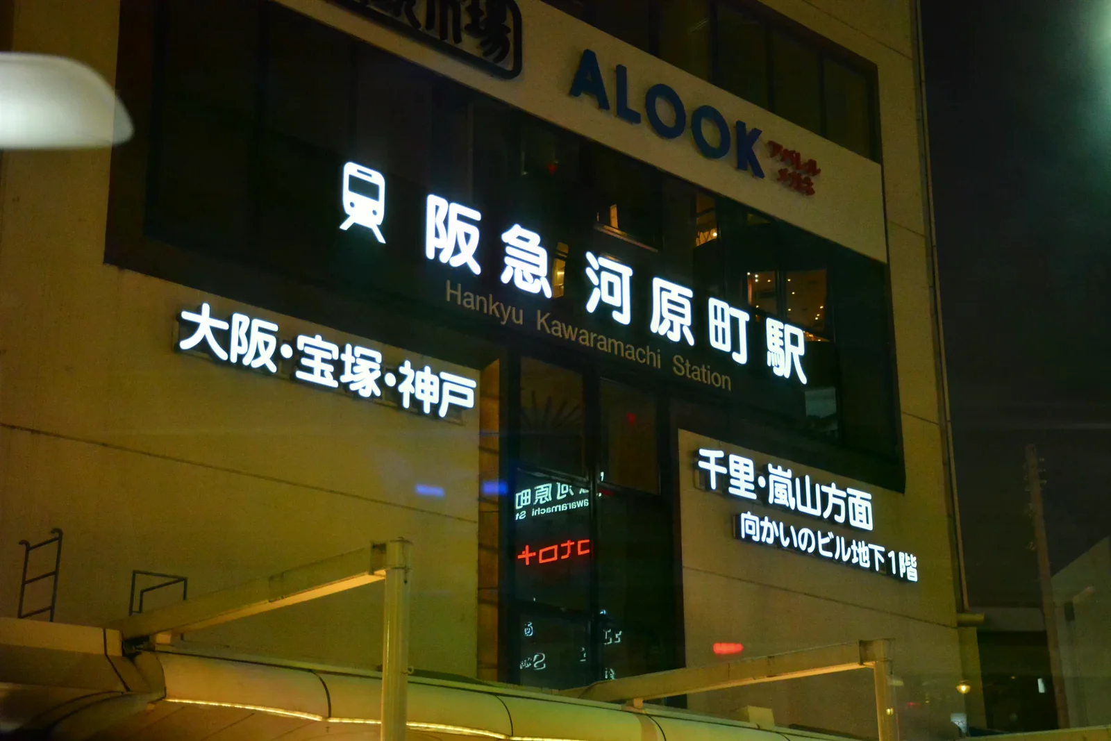 夜間亮起的阪急河原町站招牌，旁邊標示大阪、寶塚與神戶方向