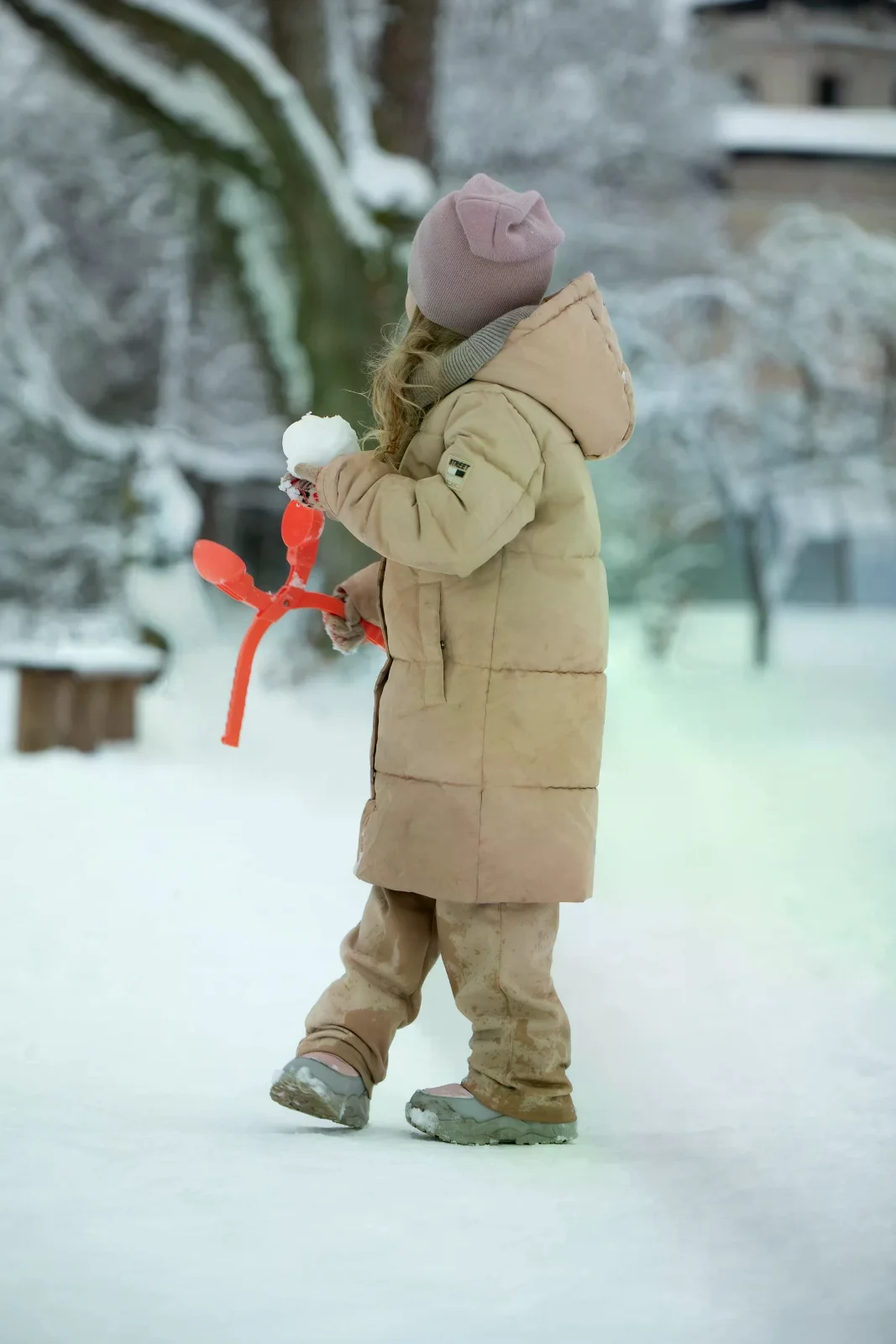 穿著冬季外套的孩子在雪地玩耍