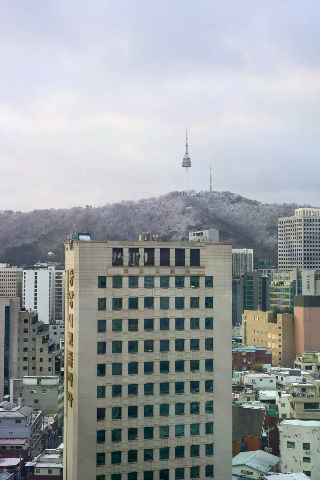 冬雪中的首爾市區建築與南山首爾塔，作為冬季旅行情境照