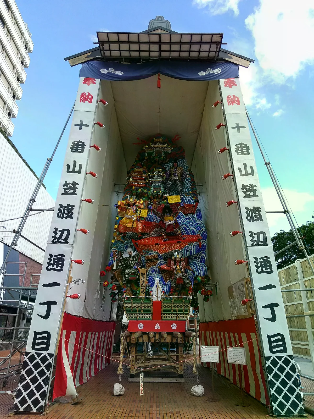 福岡市區街道上展示的博多祇園山笠裝飾山，兩側有奉納旗幟