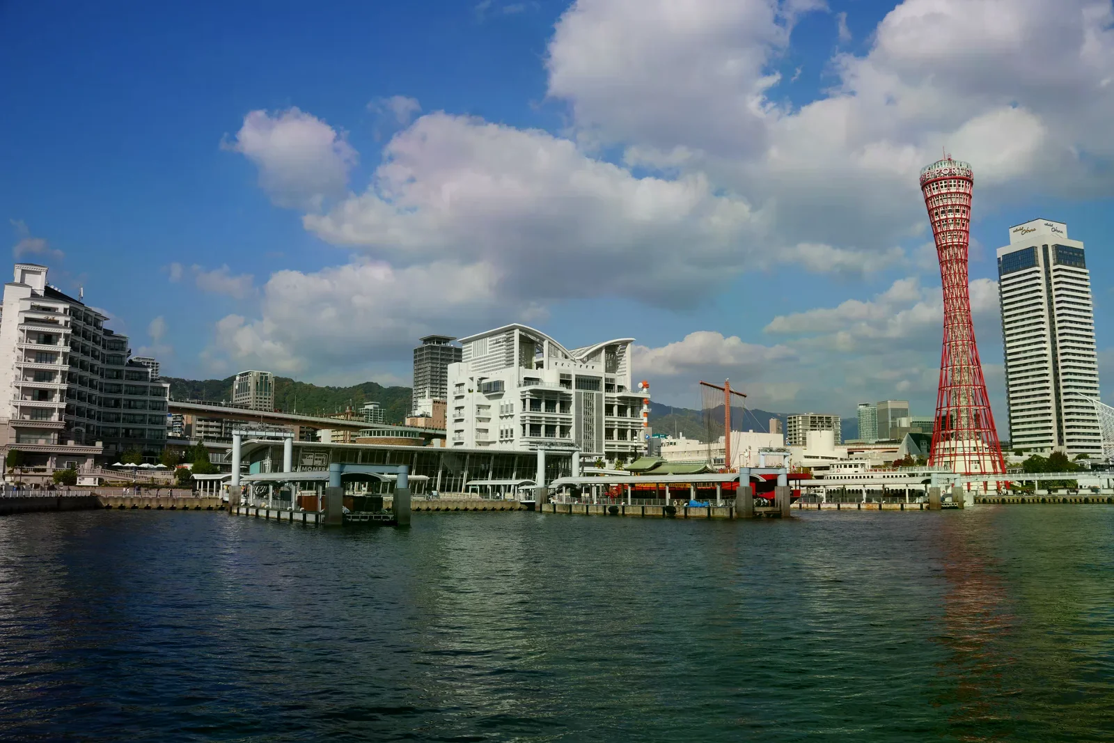 神戶港塔與海灣的港口街景，碼頭和海面在晴朗天色下相連