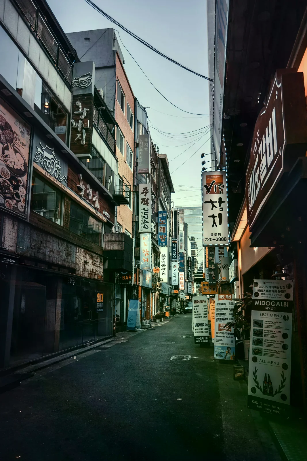首爾一條有餐館招牌的巷弄街景，呈現住宿區周邊的城市環境