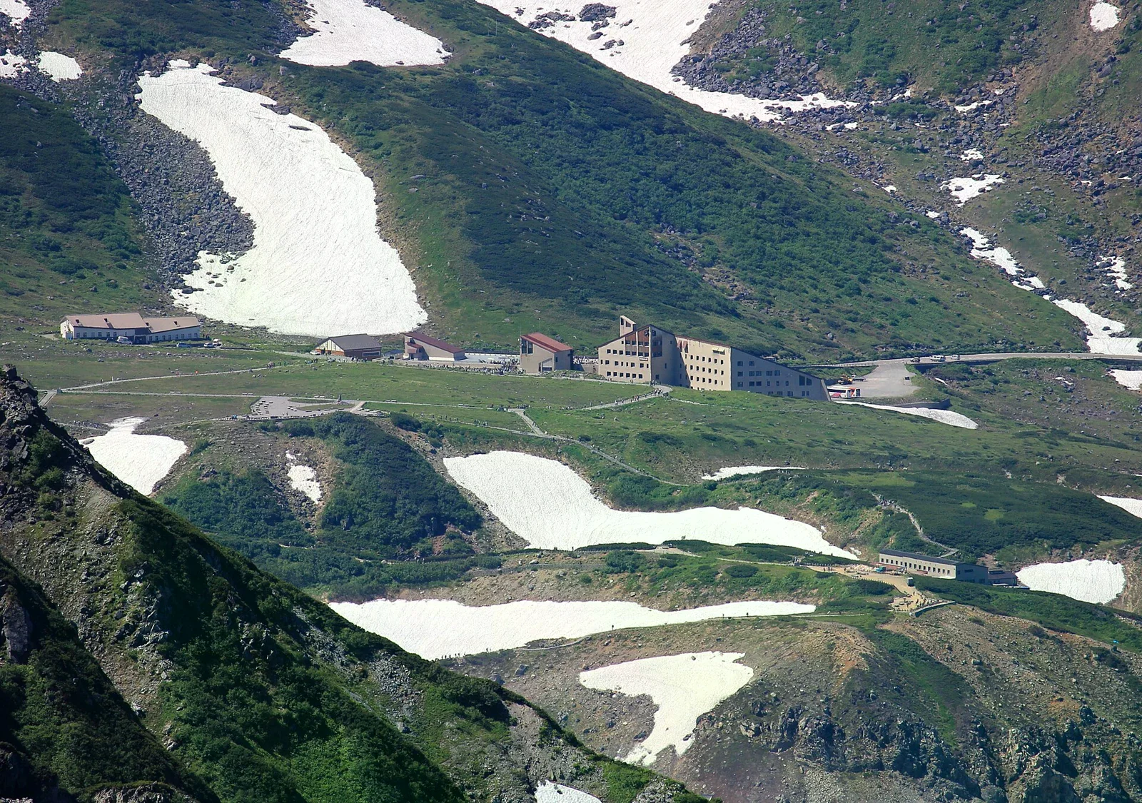從剱岳方向俯瞰立山室堂一帶的山坡、積雪與建築。