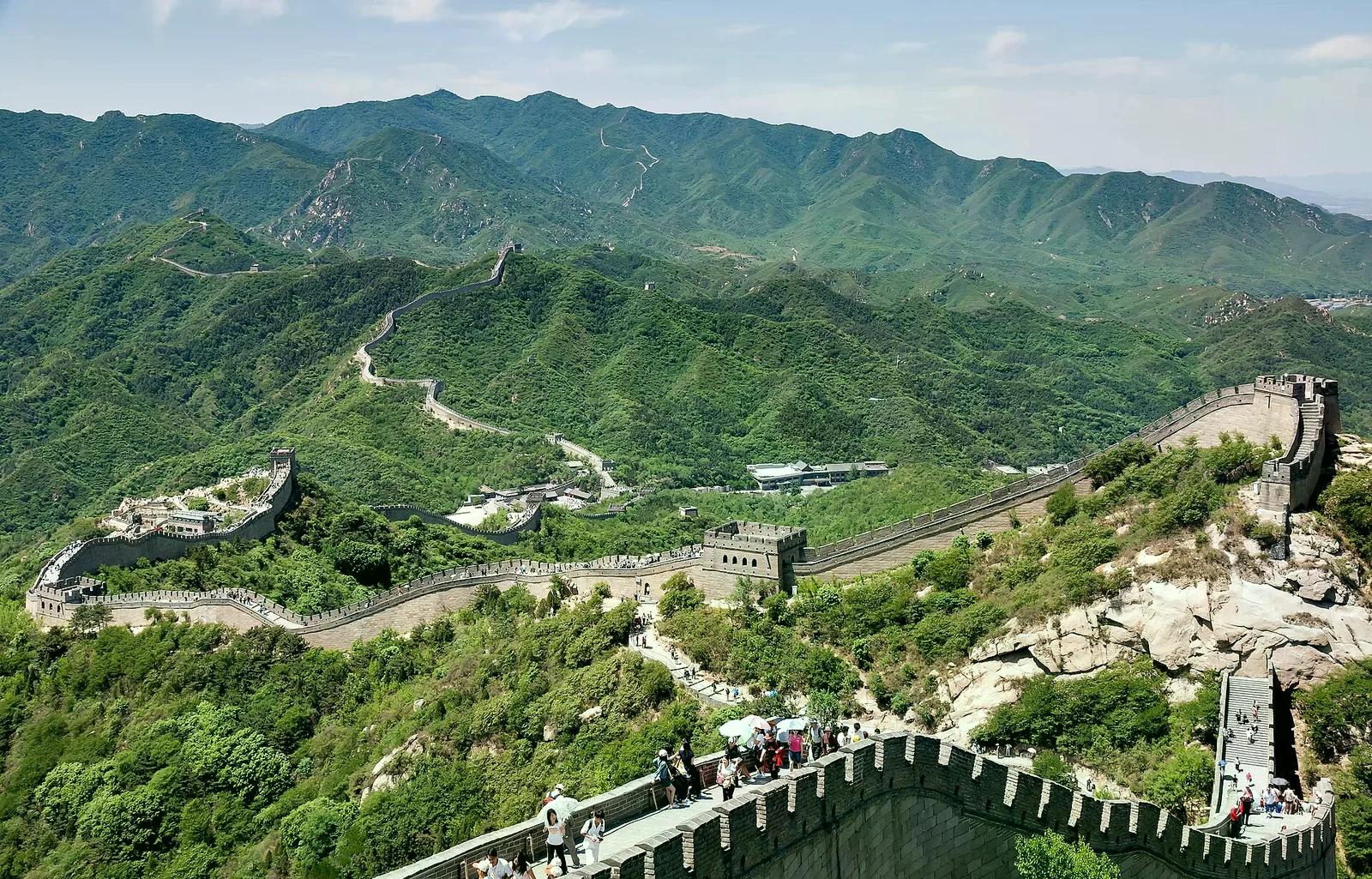 八達嶺長城沿著青翠山脊蜿蜒，可見敵樓與遊人