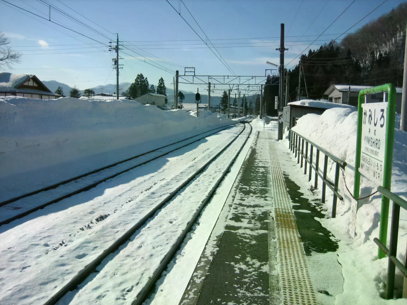 雪覆JR神城站月台與軌道，站名牌標示神城，2006年照片