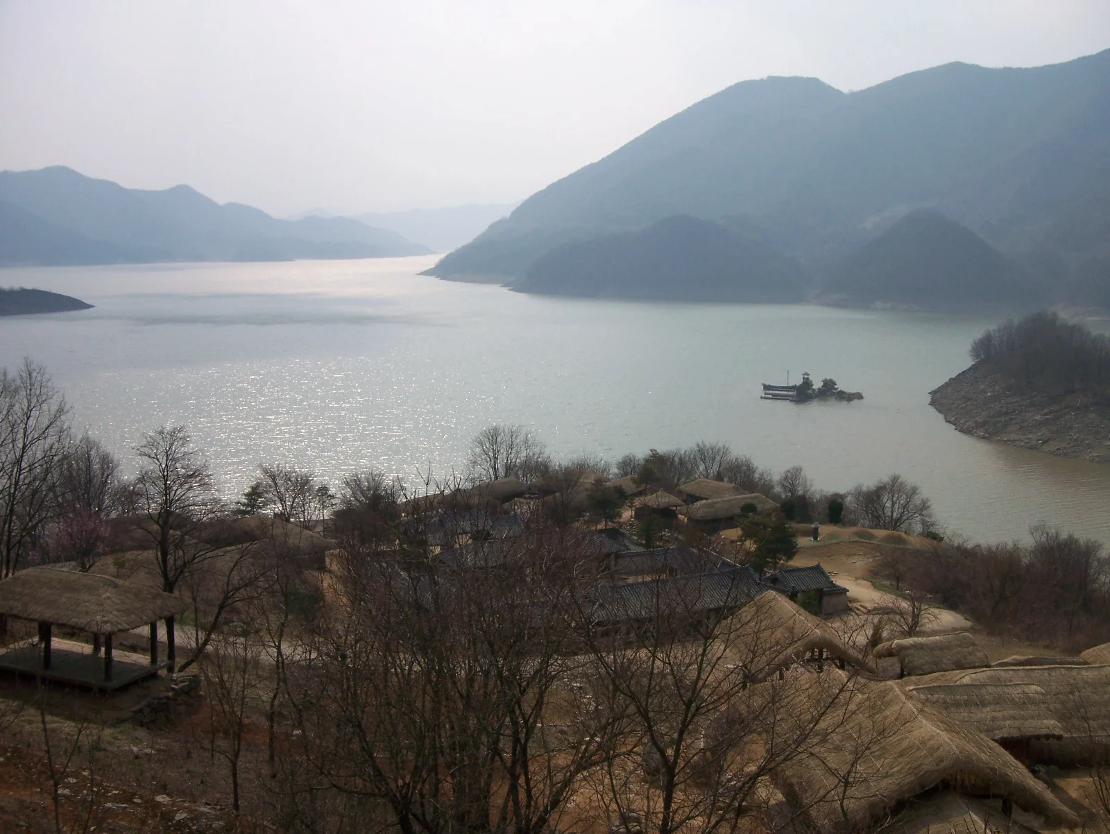 清風湖面與群山，前景可見湖岸傳統建築